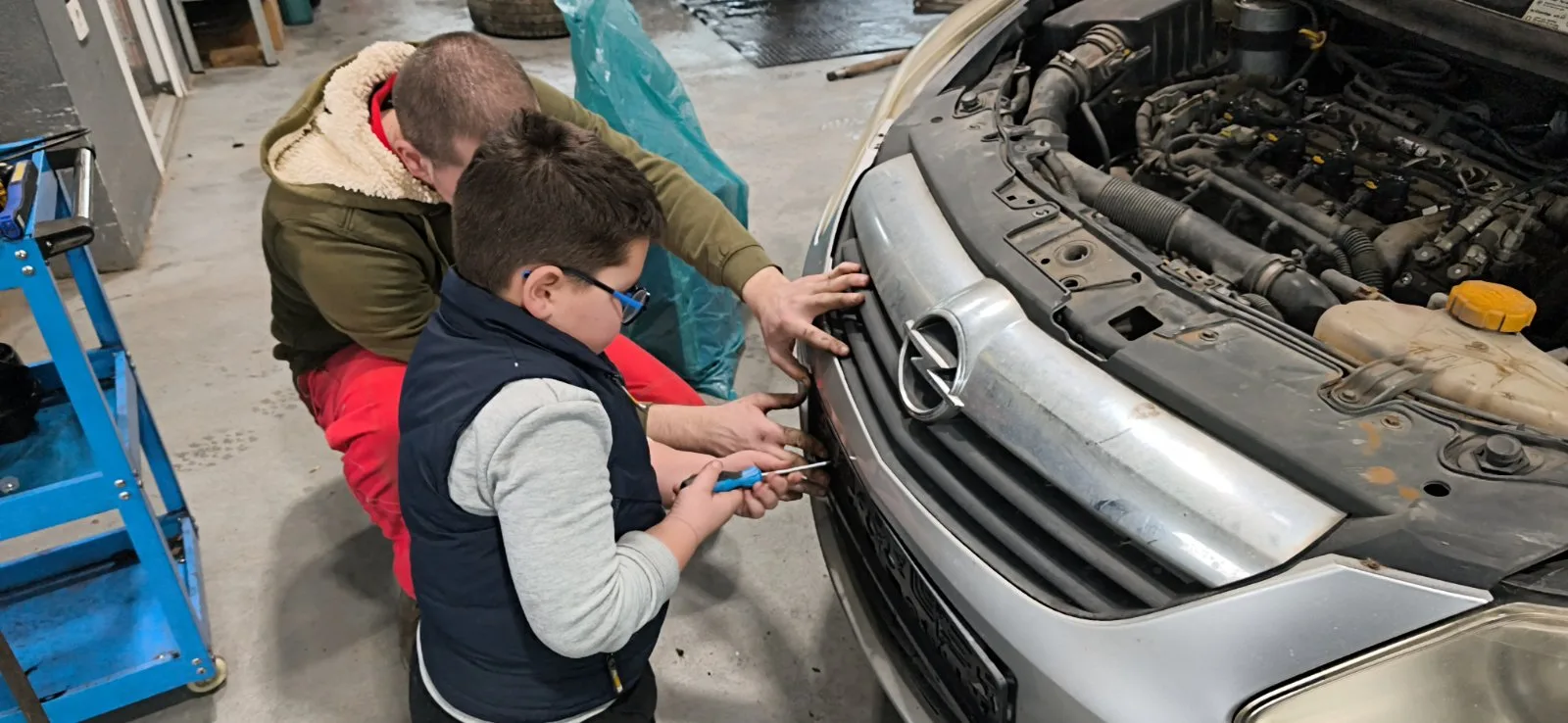 Paja sa saradnikom radi na Opel vozilu u radionici